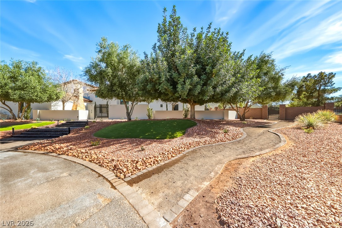1140 Julie Road Henderson, NV 89002 - Photo 16 of 38 Mature trees and a winding pathway create an inviting entrance to this desert home.