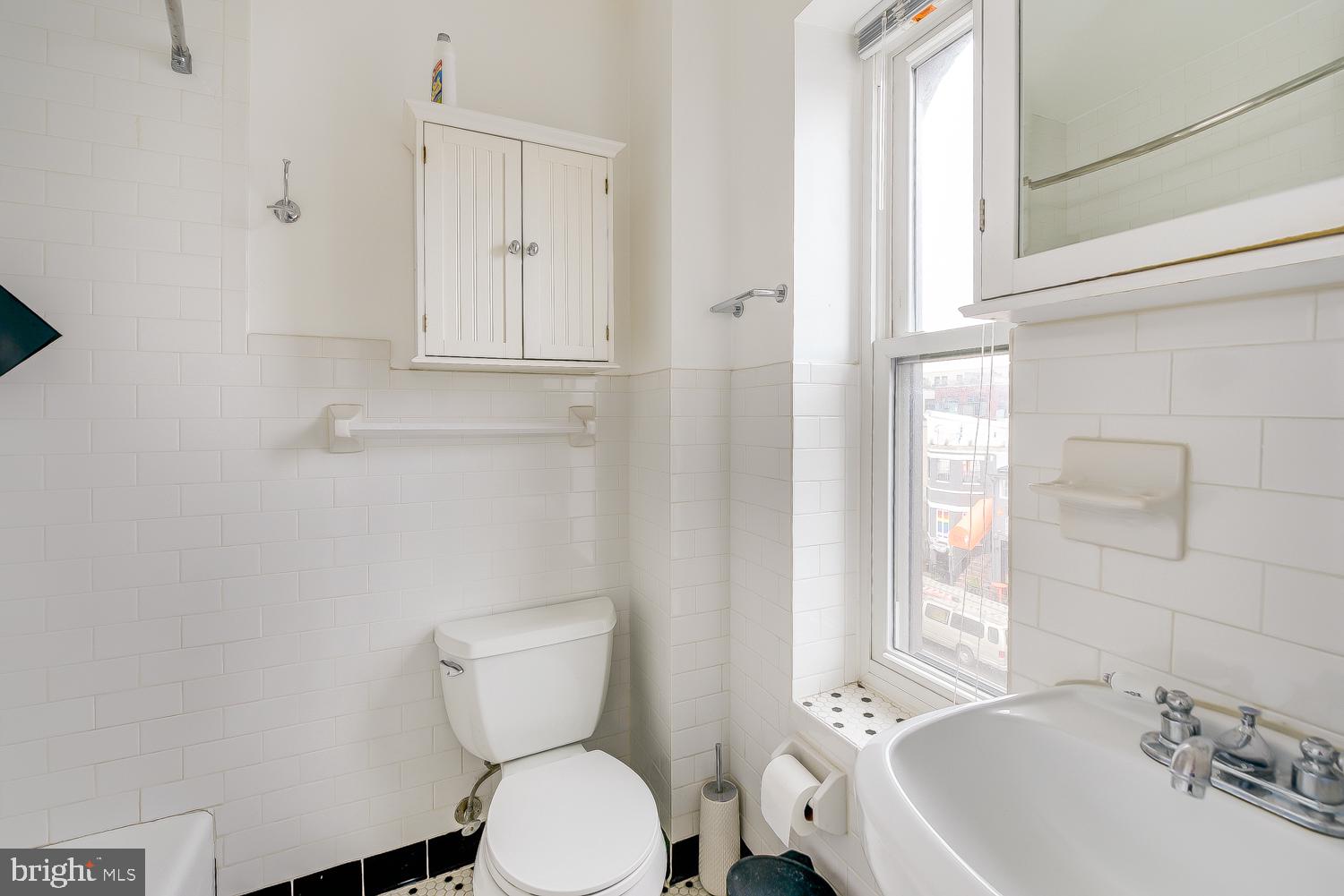 2300 18th Street Northwest, Unit 301 Washington, DC 20009 - Photo 19 of 20 a bathroom with a toilet a sink and mirror