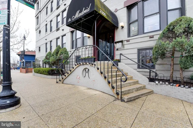 a view of a building with stairs and a bench