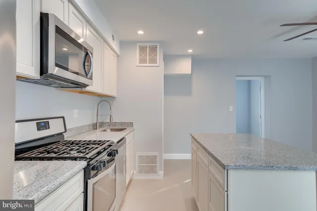 a kitchen with granite countertop a sink and a stove