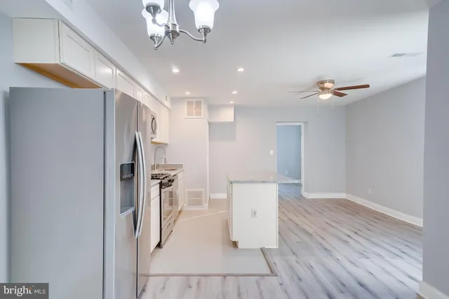 a view of a hallway with wooden floor and a chandelier