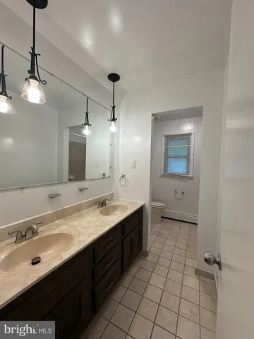 a bathroom with a double vanity sink a mirror and a shower