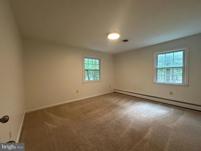 an empty room with windows and ceiling fan