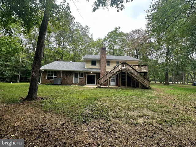 a view of a big house with a big yard and large trees