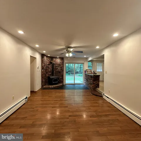 a view of a livingroom with a flat screen tv a ceiling fan and window