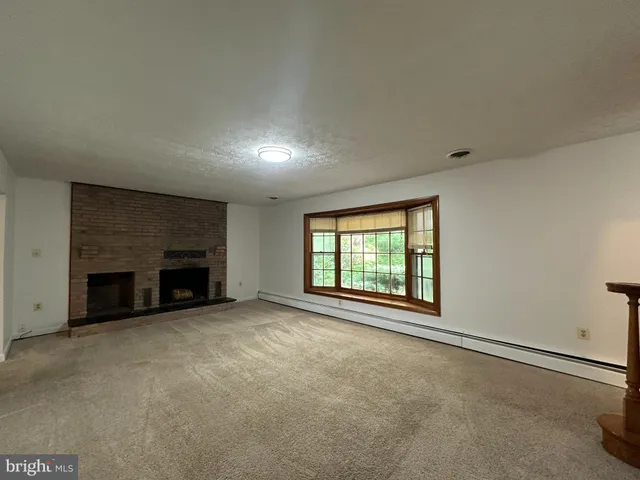 an empty room with fireplace and windows