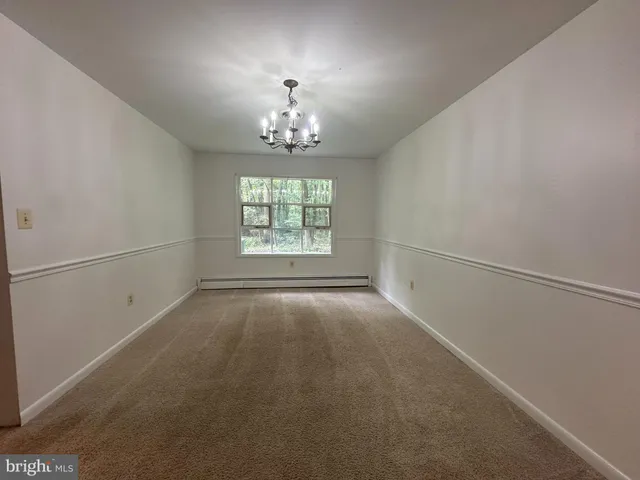 an empty room with windows and chandelier