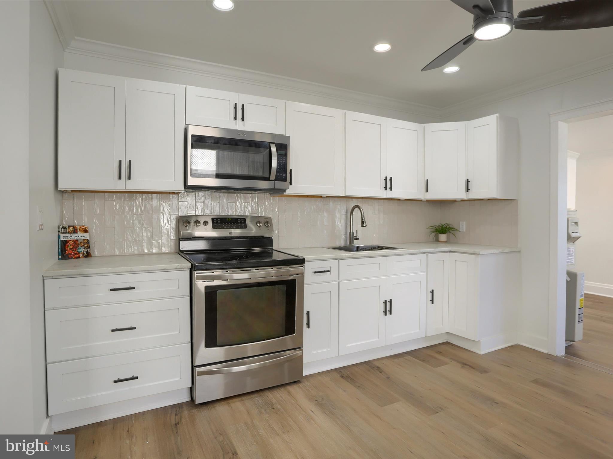 556 North 2nd Street Steelton, PA 17113 - Photo 11 of 33 a kitchen with granite countertop white cabinets and stainless steel appliances