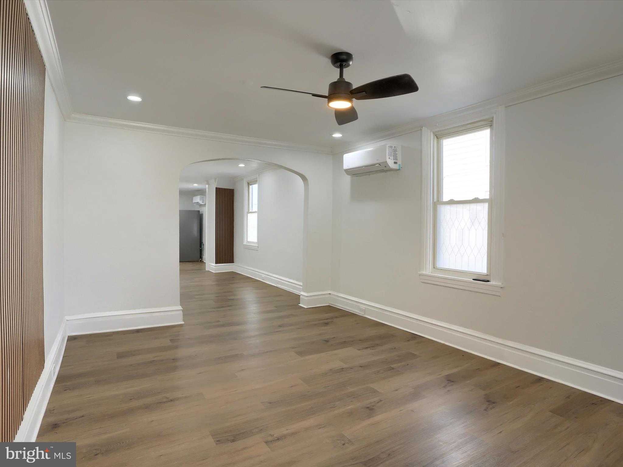 556 North 2nd Street Steelton, PA 17113 - Photo 4 of 33 an empty room with wooden floor chandelier fan and windows