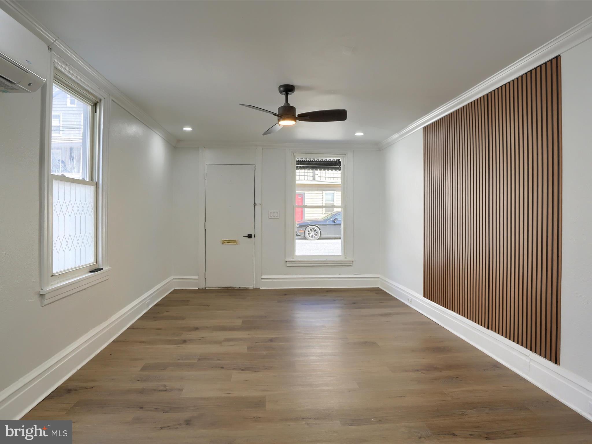 556 North 2nd Street Steelton, PA 17113 - Photo 6 of 33 an empty room with wooden floor ceiling fan and windows