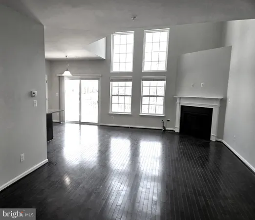 an empty room with wooden floor and a fireplace