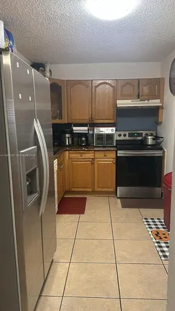 a kitchen with stainless steel appliances granite countertop a refrigerator and a stove top oven