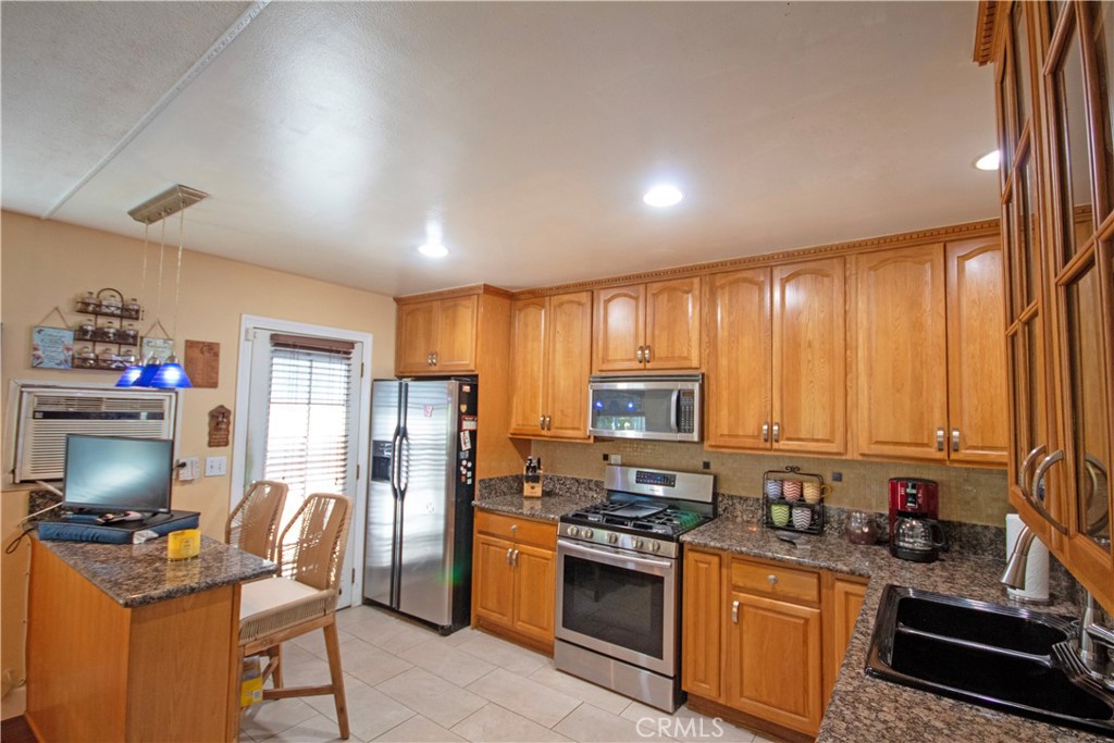 24230 Postmaster Avenue Harbor City, CA 90710 - Photo 16 of 31 a kitchen with refrigerator a stove a sink and a microwave