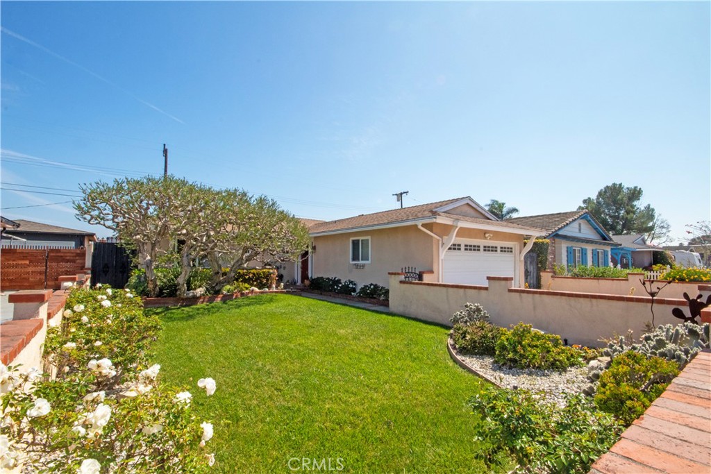 24230 Postmaster Avenue Harbor City, CA 90710 - Photo 3 of 31 a front view of a house with a yard and garage