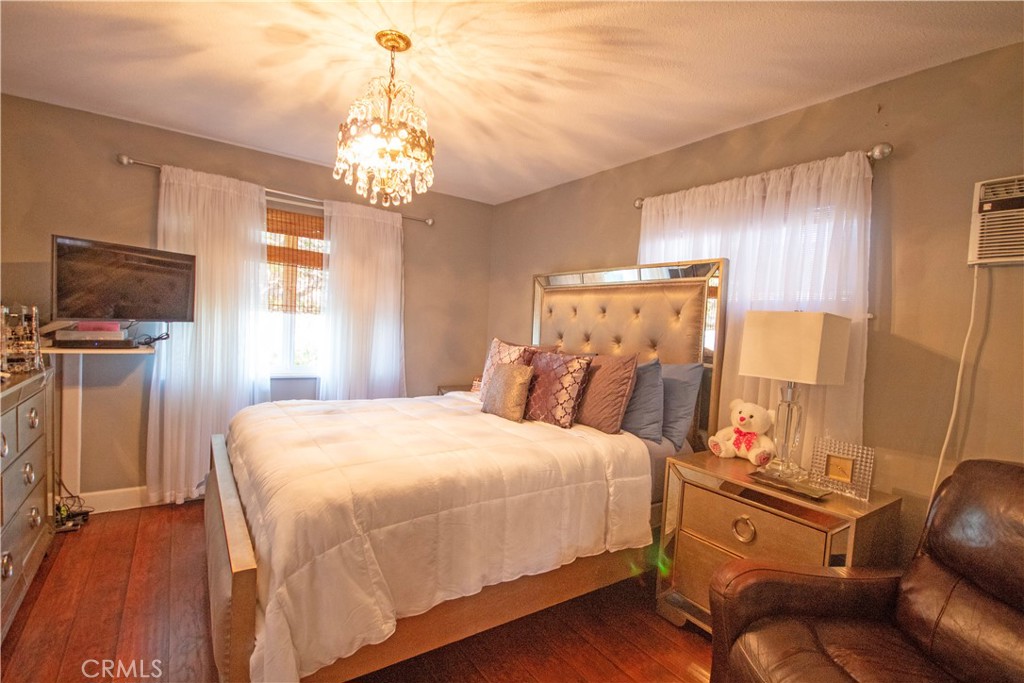 24230 Postmaster Avenue Harbor City, CA 90710 - Photo 6 of 31 a bedroom with a bed and a chandelier