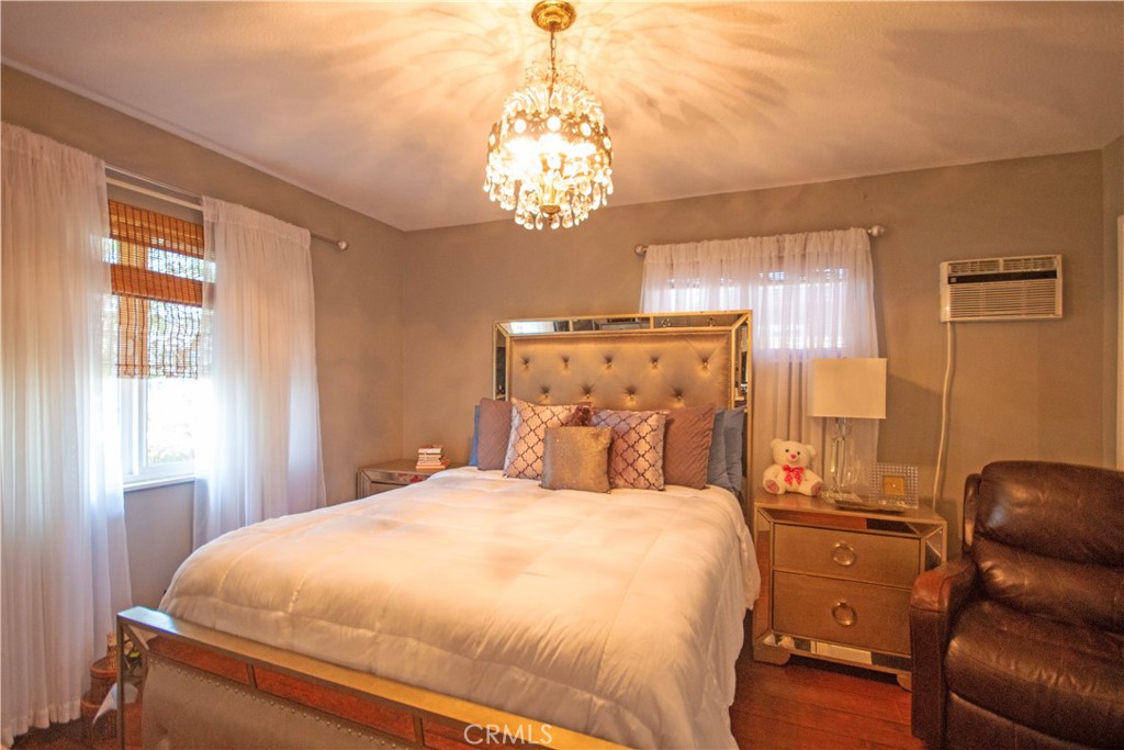 24230 Postmaster Avenue Harbor City, CA 90710 - Photo 8 of 31 a bedroom with a bed and a chandelier