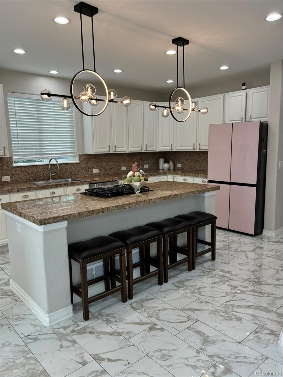 7242 South Rome Street Aurora, CO 80016 - Photo 10 of 33 a kitchen with a table and chairs in it