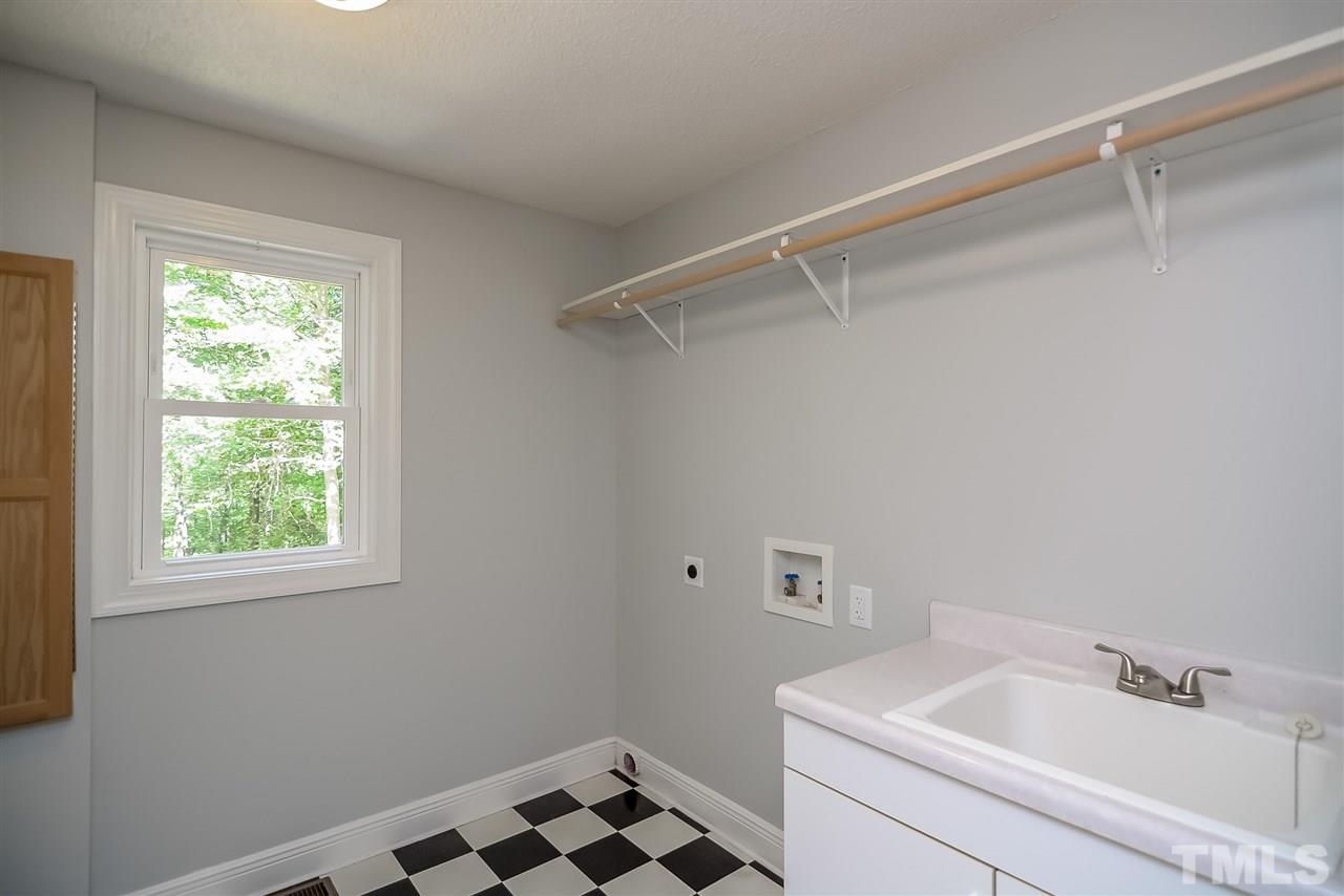 12925 Ghoston Road Wake Forest, NC 27587 - Photo 16 of 24 Laundry Room with Sink, built-in ironing board, folding counter, laundry shoot and plenty of cabinets.