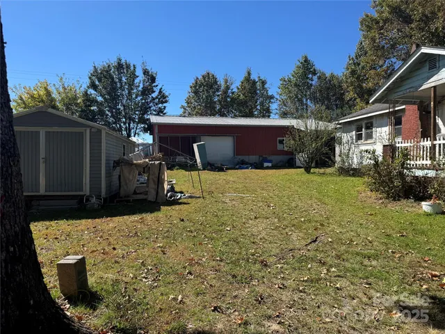 a backyard of a house with barbeque oven and trees