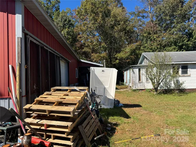 a backyard of a house with barbeque oven and plants