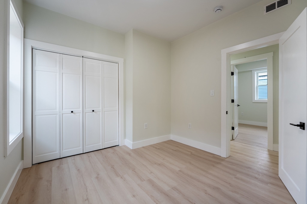 47 Brackett Street, Unit 3 Boston, MA 02135 - Photo 16 of 34 a view of an empty room with wooden floor