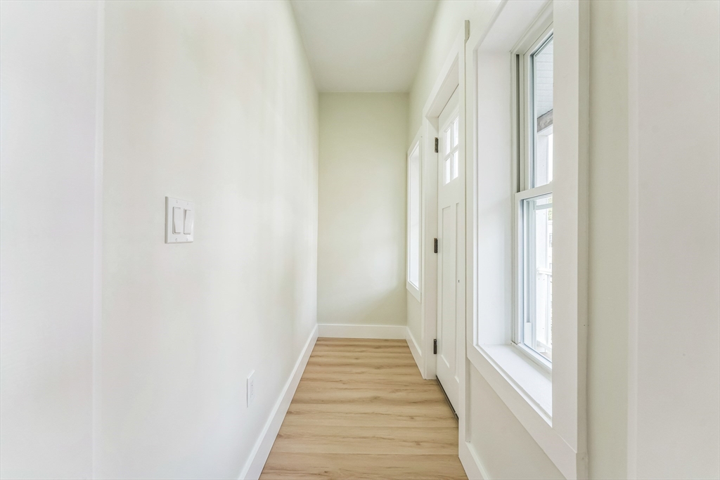 47 Brackett Street, Unit 3 Boston, MA 02135 - Photo 19 of 34 a view of a hallway with wooden floor and a large window