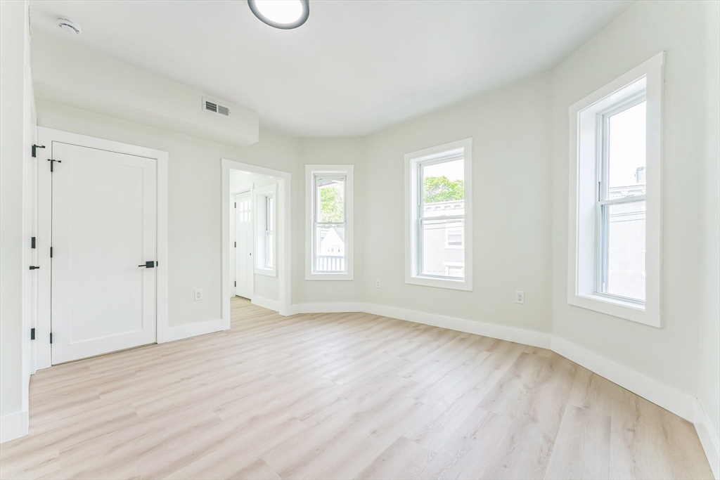 47 Brackett Street, Unit 3 Boston, MA 02135 - Photo 20 of 34 a view of an empty room with wooden floor and window