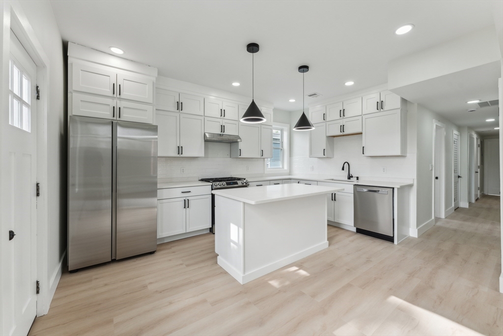 47 Brackett Street, Unit 3 Boston, MA 02135 - Photo 2 of 34 a kitchen with stainless steel appliances kitchen island a refrigerator sink and cabinets