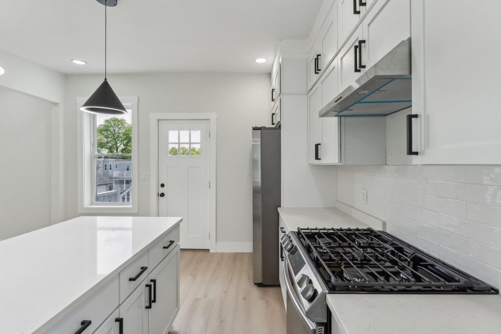 47 Brackett Street, Unit 3 Boston, MA 02135 - Photo 5 of 34 a kitchen with granite countertop a stove and a sink