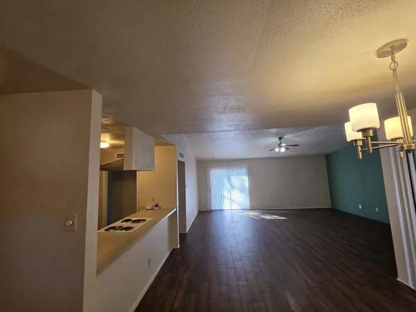 a kitchen with wooden floor and electronic appliances