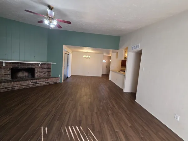 a view of a livingroom with wooden floor and a fireplace