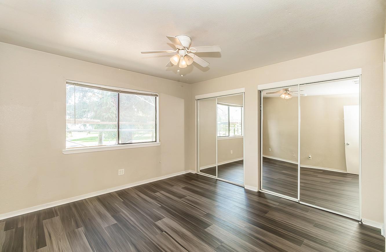 7675 North First Street, Unit 202 Fresno, CA 93720 - Photo 11 of 19 an empty room with wooden floor fan and windows