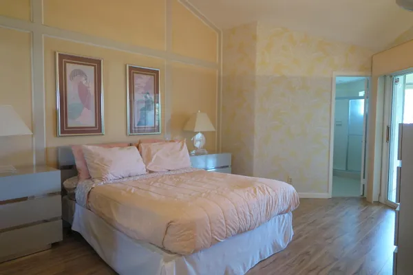a bedroom with a bed and painting on the wall