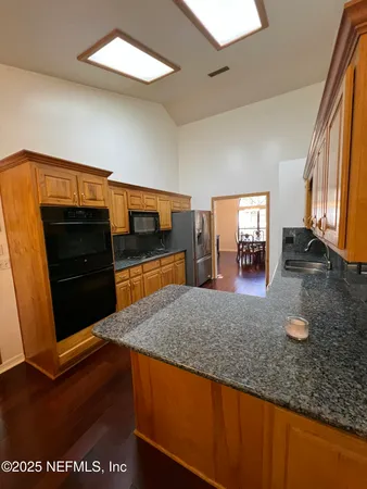 a spacious bathroom with a granite countertop sink and a mirror