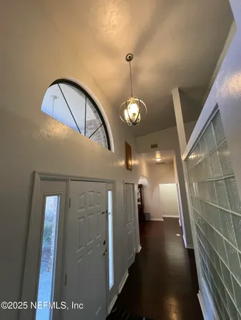 a living room with furniture a chandelier and a dining table