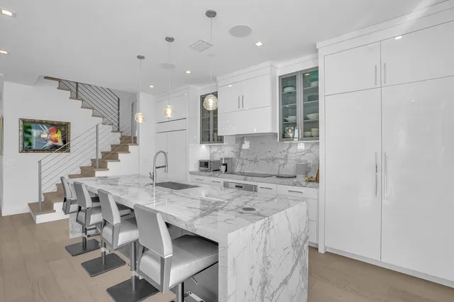 a large kitchen with stainless steel appliances kitchen island granite countertop a large counter top a stove a sink and a large window