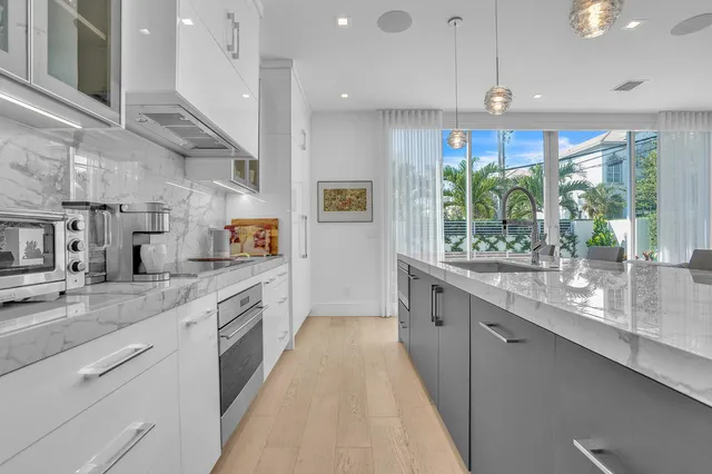 a kitchen with kitchen island a dining table chairs sink and cabinets
