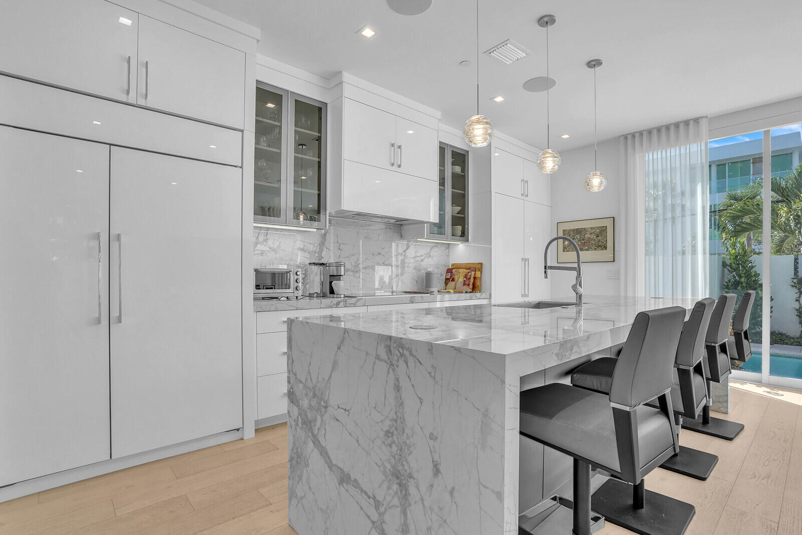 200 Northeast 7th Avenue, Unit 3 Delray Beach, FL 33483 - Photo 14 of 71 a kitchen with kitchen island a dining table chairs sink and cabinets