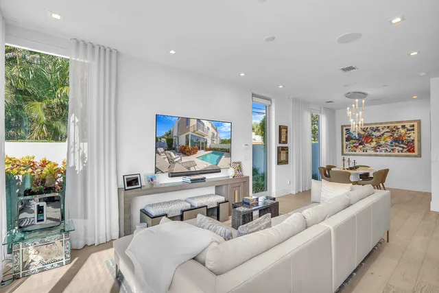a large white kitchen with a large window and stainless steel appliances