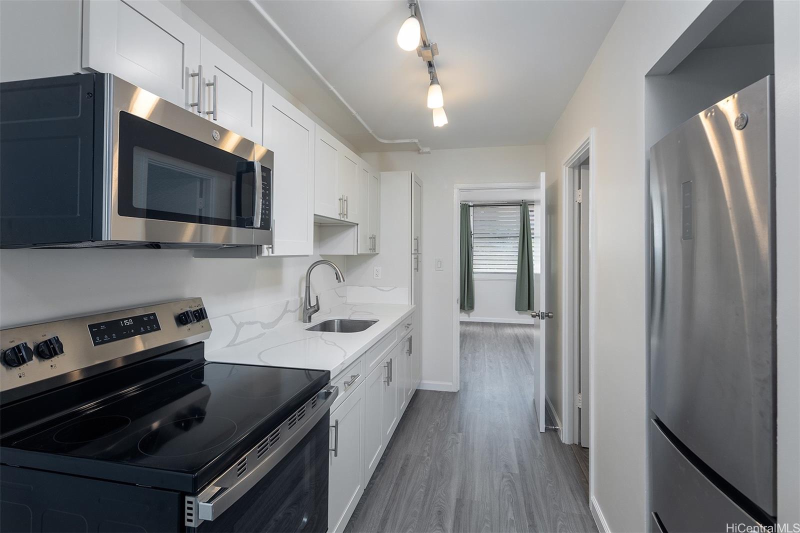 a kitchen with stainless steel appliances a stove sink microwave and cabinets