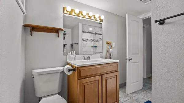 a bathroom with a sink a toilet and shower