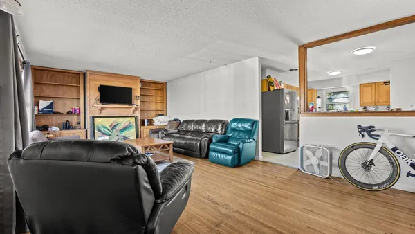 a living room with furniture a window and a flat screen tv