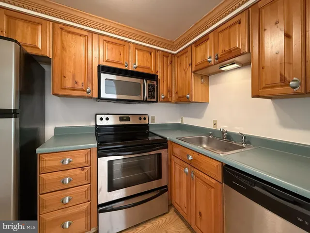 a kitchen with granite countertop cabinets stainless steel appliances and a sink