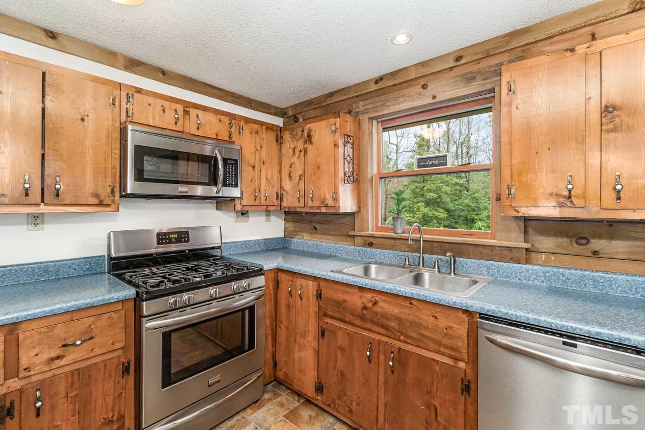 148 Nutbush Road Manson, NC 27553 - Photo 12 of 30 a kitchen with granite countertop a stove top oven sink and cabinets