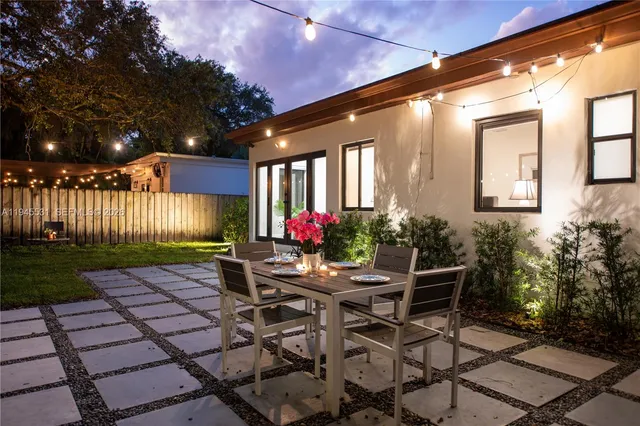 a view of a patio with table and chairs with wooden fence and plants