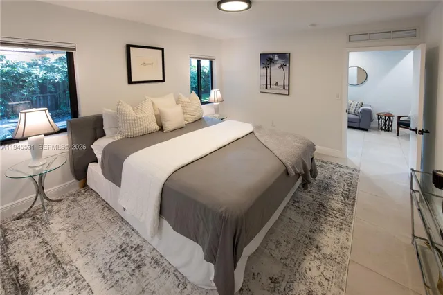 a bed room with a bed and three large mirror