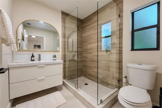 a bathroom with a sink a toilet and shower