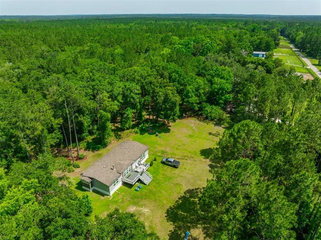 an aerial view of a house with yard swimming pool and outdoor seating