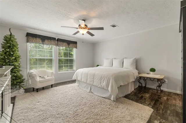 a spacious bedroom with a bed a couch and large window