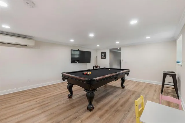 a room with wooden floor and pool table